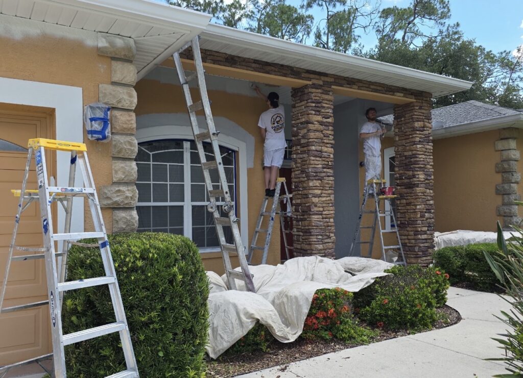 Painters Near Me crew preparing a home exterior with surrounding surfaces covered