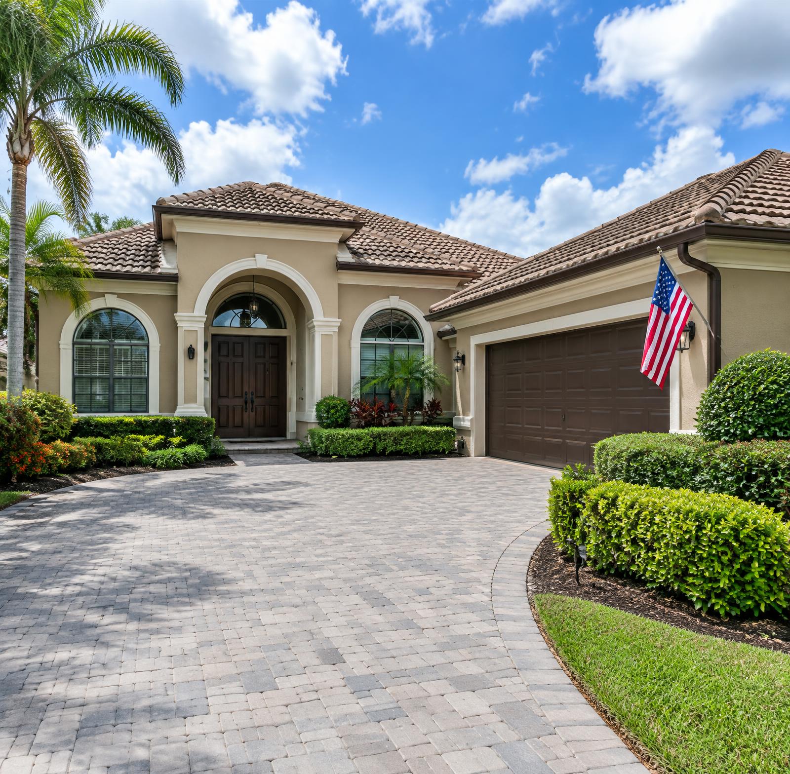 Freshly painted Florida home with tan stucco, tile roof and paver driveway